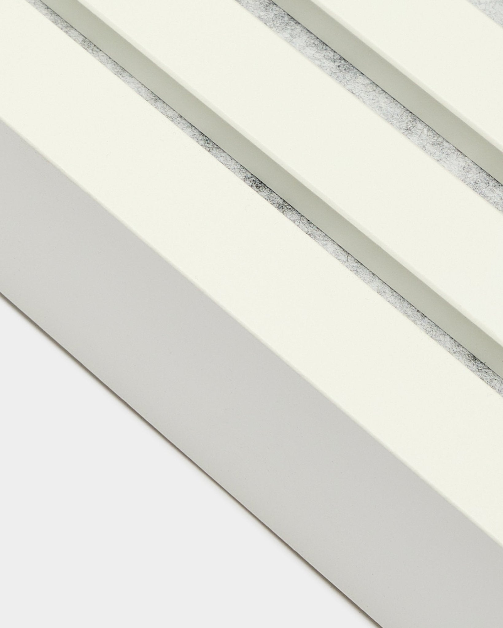 Gros plan sur la lamelle d’extrémité WoodUpp en Snow, 6,7 cm de large, avec cadre en MDF, double rainurage et finition texturée grey pour une installation murale Panneau acoustique Akupanel.
